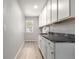 A spacious laundry room with white cabinetry and a dark stone countertop at 664 Clarendon Dr, Longmont, CO 80504