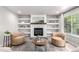 Cozy living room with a fireplace, built-in shelves, comfortable seating, and ample natural light at 664 Clarendon Dr, Longmont, CO 80504