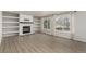 Bright living room features a fireplace flanked by built-in shelving and large windows with natural light at 664 Clarendon Dr, Longmont, CO 80504