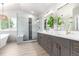Modern bathroom boasts dual sink vanity, luxurious glass shower, and an elegant freestanding tub at 664 Clarendon Dr, Longmont, CO 80504