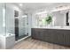 Modern bathroom with dual sink vanity, glass enclosed shower, and wood-look floors at 664 Clarendon Dr, Longmont, CO 80504