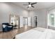 Bright main bedroom with wood floors, tall mirror, and accent chair at 664 Clarendon Dr, Longmont, CO 80504