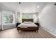 This main bedroom features many windows, light wood floors, and a sleek platform bed at 664 Clarendon Dr, Longmont, CO 80504