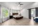 A spacious main bedroom features a modern ceiling fan, wood flooring, and a barn door to the bathroom at 664 Clarendon Dr, Longmont, CO 80504