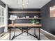 Stylish home office featuring wood desk, floating shelves, modern lighting, and dark accent wall at 664 Clarendon Dr, Longmont, CO 80504