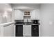 Basement wet bar with black countertop and appliances and white cabinetry providing a sleek space at 664 Clarendon Dr, Longmont, CO 80504