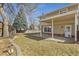 Backyard view features a covered patio, grass area and mature trees at 7867 S Poplar Way, Centennial, CO 80112