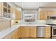 Well-lit kitchen featuring light wood cabinets, stainless steel appliances, and white countertops at 7867 S Poplar Way, Centennial, CO 80112