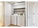 Convenient laundry room with washer, dryer, shelving, and bi-fold doors at 7867 S Poplar Way, Centennial, CO 80112