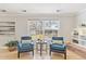 Bright living room with two blue chairs, hardwood floors and access to backyard at 7867 S Poplar Way, Centennial, CO 80112