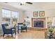 Comfortable living room showcases a brick fireplace, large windows and hardwood floors at 7867 S Poplar Way, Centennial, CO 80112