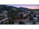 Aerial view showcasing luxury homes nestled among lush trees and winding roads at 22419 Springflower Dr, Golden, CO 80401