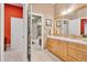 Bright bathroom with light wood cabinets, a large mirror, and a view to the stone accent wall at 22419 Springflower Dr, Golden, CO 80401
