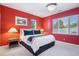 Inviting bedroom featuring a comfortable king-sized bed, two windows, and warm red walls at 22419 Springflower Dr, Golden, CO 80401