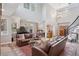 Bright living room with leather sofas, fireplace, high ceilings, and a grand piano at 22419 Springflower Dr, Golden, CO 80401