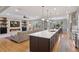 Open-concept kitchen and living area with a modern fireplace and hardwood floors at 22419 Springflower Dr, Golden, CO 80401