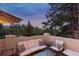 Outdoor lounge area featuring comfortable white seating and views of the forest at 22419 Springflower Dr, Golden, CO 80401