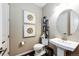 Stylish half-bathroom featuring a pedestal sink, decorative mirror, and elegant wall art at 350 Vista Cliff Cir, Castle Rock, CO 80104