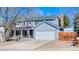 Two-story home with a covered porch, two car garage, and a long driveway in a residential neighborhood at 1109 E 7Th Avenue Cir, Broomfield, CO 80020