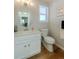 Bright half-bathroom featuring modern fixtures, a vanity with a sink, and elegant hardwood floors at 1109 E 7Th Avenue Cir, Broomfield, CO 80020