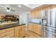 Spacious kitchen featuring stainless steel refrigerator, wooden cabinets, and black countertops at 1109 E 7Th Avenue Cir, Broomfield, CO 80020