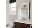 Bathroom featuring a dark wood vanity with a white countertop, modern fixtures, and a window for natural light at 6068 Beeler Ct, Denver, CO 80238