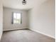 Bright bedroom featuring neutral walls, carpet floors, a modern light fixture, and a window offering natural light at 6068 Beeler Ct, Denver, CO 80238