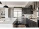 Sleek kitchen featuring stainless steel appliances, dark cabinetry, and an island with countertop seating at 6068 Beeler Ct, Denver, CO 80238