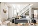 Inviting living room bathed in natural light featuring a cozy seating area and staircase at 6068 Beeler Ct, Denver, CO 80238