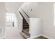 Bright staircase with carpeted steps, a dark metal railing, and white walls at 6068 Beeler Ct, Denver, CO 80238