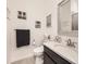 Cozy bathroom featuring a vanity with marble counters, a decorative mirror, and beach themed artwork at 15747 Willow Way, Thornton, CO 80602