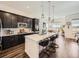 Contemporary kitchen featuring dark cabinetry, white countertops, stainless steel appliances, and a breakfast bar at 15747 Willow Way, Thornton, CO 80602