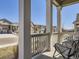 Cozy covered porch with columns, a railing, and chairs overlooking the manicured front yard at 15747 Willow Way, Thornton, CO 80602