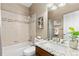 Bathroom featuring a bathtub with shower, granite countertops, and ceramic tiling at 12935 Lafayette St # B, Thornton, CO 80241