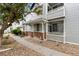Charming townhome featuring a covered porch with brick accents and well-maintained landscaping at 12935 Lafayette St # B, Thornton, CO 80241