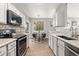 Modern kitchen with stainless steel appliances, granite countertops, and gray cabinets at 12935 Lafayette St # B, Thornton, CO 80241