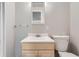 Compact bathroom with wood vanity, white sink, and a toilet at 8791 Troon Village Pl, Lone Tree, CO 80124