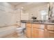 Bathroom featuring a granite countertop, wood cabinets, and tub with tile surround at 8791 Troon Village Pl, Lone Tree, CO 80124