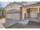 Close-up of the home's entrance, highlighting the brick accents, covered porch, and well-lit doorway at 8791 Troon Village Pl, Lone Tree, CO 80124