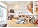 Comfortable living room with a fireplace, a TV, large windows and staircase to the second floor at 1851 Ute Creek Dr, Longmont, CO 80504