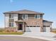 Charming two-story home boasts a stone facade and three-car garage on a sunny day at 1965 S Coolidge Way, Aurora, CO 80018