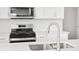 Bright kitchen features stainless steel appliances, white cabinets, and white countertops at 1965 S Coolidge Way, Aurora, CO 80018