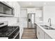 Bright kitchen features stainless steel appliances, white cabinets, white countertops, and wood flooring at 1965 S Coolidge Way, Aurora, CO 80018