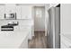 Bright kitchen features stainless steel appliances, white cabinets, white countertops, and wood flooring at 1965 S Coolidge Way, Aurora, CO 80018