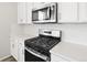 Bright kitchen features stainless steel appliances, white cabinets, and white countertops at 1965 S Coolidge Way, Aurora, CO 80018