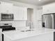Bright kitchen features stainless steel appliances, white cabinets, white countertops, and wood flooring at 1965 S Coolidge Way, Aurora, CO 80018
