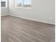 Bright, empty room with wood-look flooring and large window with horizontal blinds at 1965 S Coolidge Way, Aurora, CO 80018