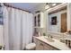 Bathroom features white shower curtain, vanity, floral accents, and ample storage at 4933 Altura St, Denver, CO 80239