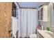 Bathroom features white shower curtain, vanity, floral accents, and a wood door at 4933 Altura St, Denver, CO 80239