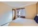 Bedroom view featuring a white comforter, window with curtains, and a carpeted floor at 4933 Altura St, Denver, CO 80239